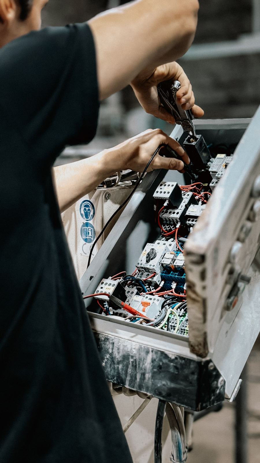 Elektriker arbeitet an einem Sicherungskasten